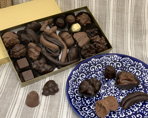 Chocolate covered fruit and chocolate covered nuts within a gold one pound box